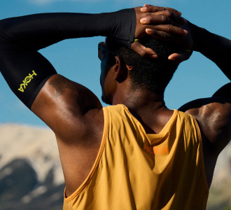 Man wearing HOKA gear looking at mountains.