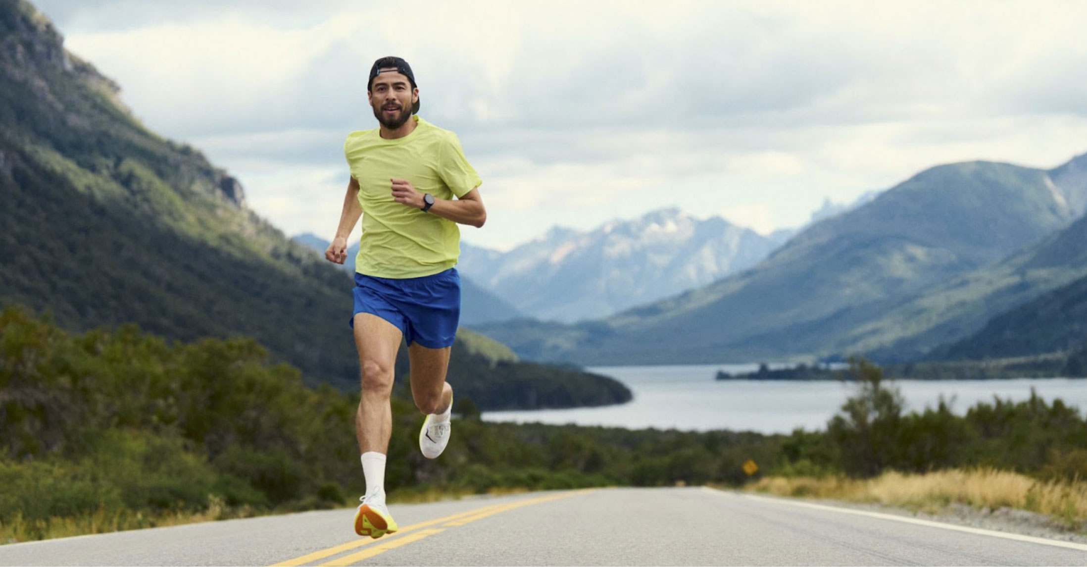 Man running on a road wearing HOKA shoes.