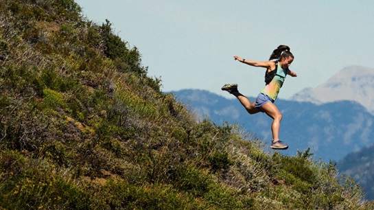 Woman running down a gravel trail.