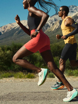 Three runners on a road, with mountains in the distance.